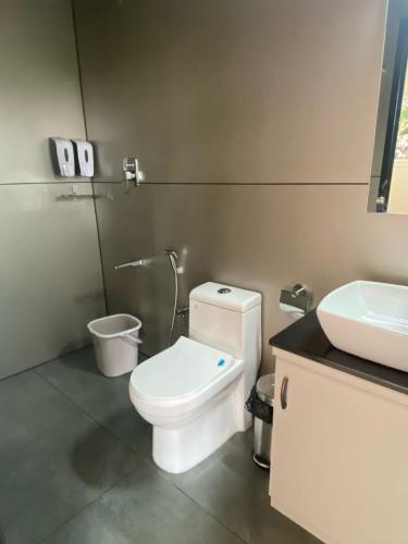 a bathroom with a white toilet and a sink at Tree Valley Resort Wayanad in Meppādi