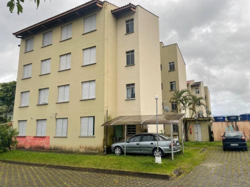 モンガグァーにあるApartamento do Guerreiro com Área Gourmet e Redarioの大きな建物の前に停車する車