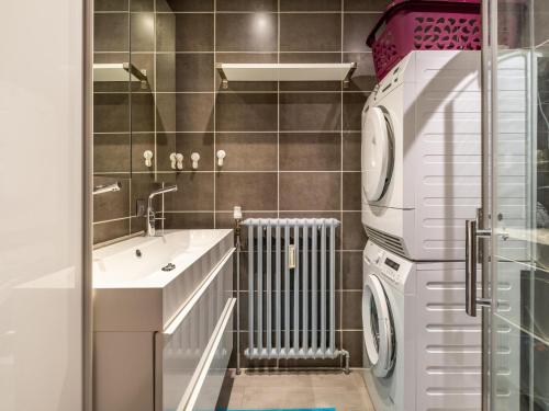 a bathroom with a sink and a washer and dryer at Zeezicht GV in Galopen