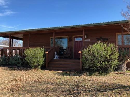 una casa con porche y un gato sentado en el porche en The Windmill Farm and Bed & Breakfast, en Tolar