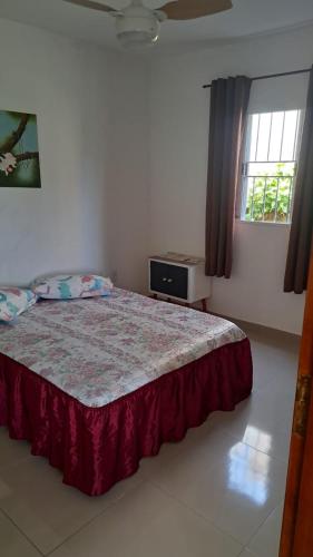 a bedroom with a bed and a window at Chalé Zarinha I in Serra Negra
