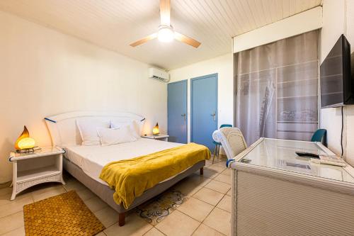 Un dormitorio con una cama, un escritorio y un televisor. en Le refuge des 3Fs, en Sainte-Marie