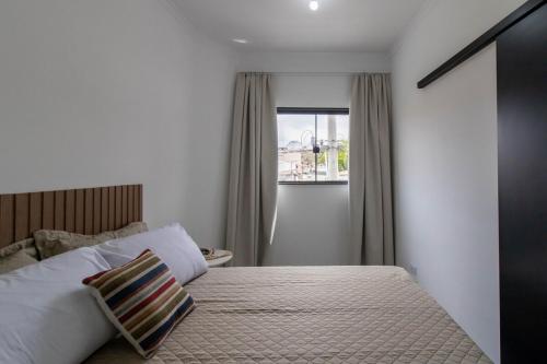 a bedroom with a bed and a window at 0804 Orquídea Studio Próx GRU e Estação Cecap in Guarulhos