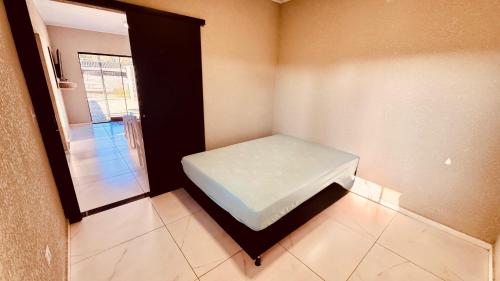 a small room with a bed and a window at aconchegante com piscina e churrasqueira, pertinho da praia" in Itapoa