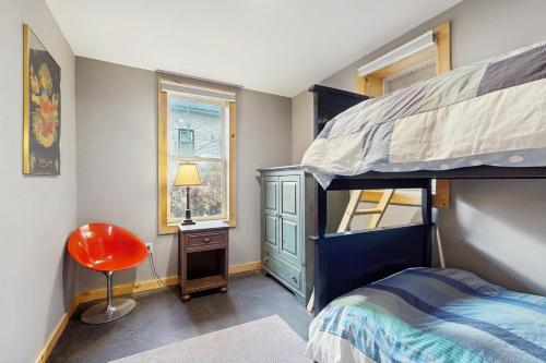 a bedroom with a bunk bed and a red chair at The River House in West Wardsboro