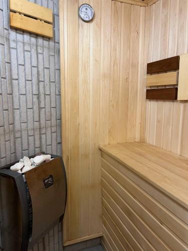 a sauna with a clock on a wooden wall at Continental Hotel & Sauna in Vanadzor