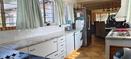 Una cocina con gabinetes blancos y un fregadero. en 7atSapele, en Germiston