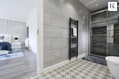 ein Badezimmer mit Dusche, Bett und Toilette in der Unterkunft Luxury Group Stay With Bar, 80-inch TV and Parking - Sleeps 10 - By EKLIVING 