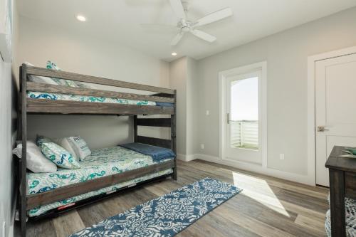 ein Schlafzimmer mit Etagenbetten und Deckenventilator in der Unterkunft Luxury Gulf Views Pool Exclusive Villa in Bolivar Peninsula