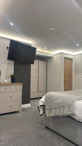 a bedroom with a bed and a flat screen tv at Cloud Quarters II in Wakefield