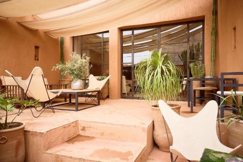 a patio with a table and chairs and plants at Riad Caravane in Aït Ben Haddou