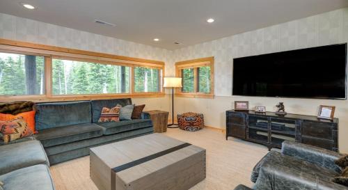 a living room with a couch and a flat screen tv at Challenger Cabin in Big Sky Mountain Village