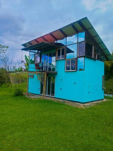 a blue house with a glass facade at El Huerto del Edén in Armenia