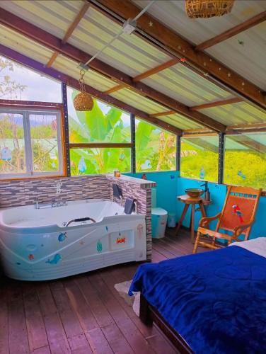 a bedroom with a tub and a bed in a room at El Huerto del Edén in Armenia