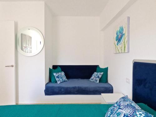 a blue couch in a room with a mirror at Apartment Edificio Altemar in Playa de las Americas