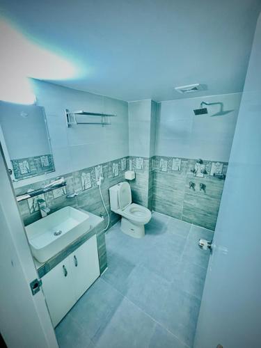 a bathroom with a white toilet and a sink at The Grand Mafi Hotel & Spa in Sylhet