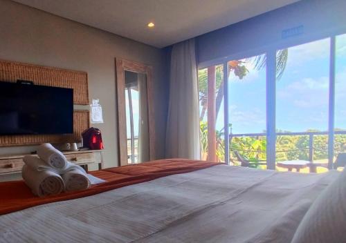 a bedroom with a large bed and a large window at Pousada Recanto in Fernando de Noronha