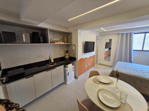 a kitchen and dining room with a table and chairs at Flat Aconchego beira mar Cabo Branco - 606 entre o mar e a mata Atlantica in João Pessoa