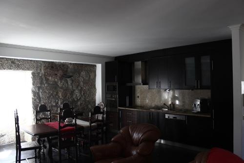 Una cocina y un comedor con mesa y sillas. en Villas da Quintã, en Cabeceiras de Basto