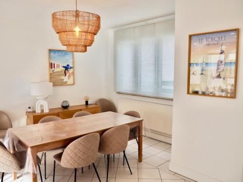 een eetkamer met een houten tafel en stoelen bij Charmante Villa 5 min de la plage et garage in Le Touquet-Paris-Plage