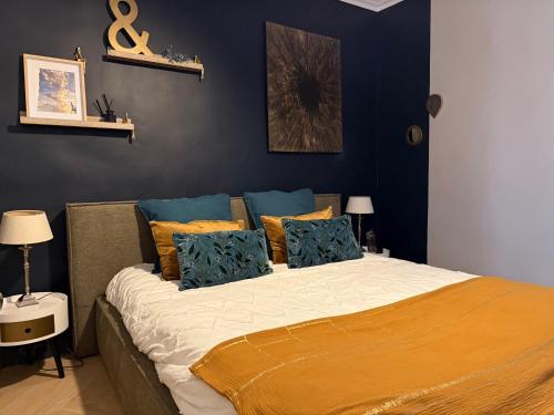 a bedroom with a large bed with blue walls at Le Mistral Sétois climatisé en plein cœur de ville in Sète