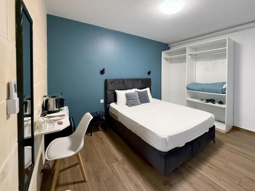 Un dormitorio con una cama y una pared azul. en Mini Studios in Central Victoria, en Victoria