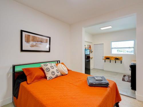 a bedroom with a bed with an orange blanket at Miami Luxury Studio, Close to Wynwood and Beach in Biscayne Park