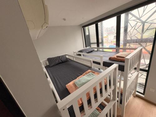 two bunk beds in a room with a window at The Family Suites Serviced Apartments in Singapore
