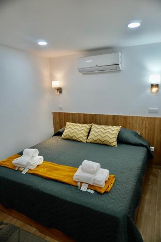 a bedroom with a bed with two towels on it at Casa Tapada do Bento II- Albufeira in Albufeira