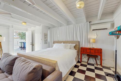 Un dormitorio con una cama, un sofá y una mesa. en Kahaone Family Retreat (30+ night rental), en Waialua