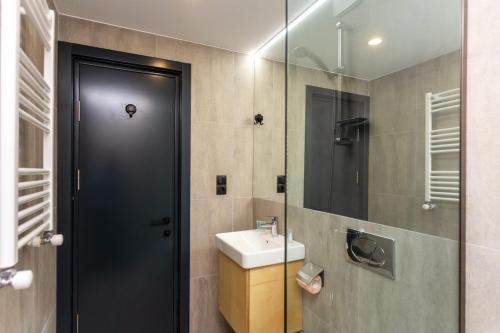 a bathroom with a sink and a glass shower door at 1BR Apart In Kokhta Mitarbi in Bakuriani
