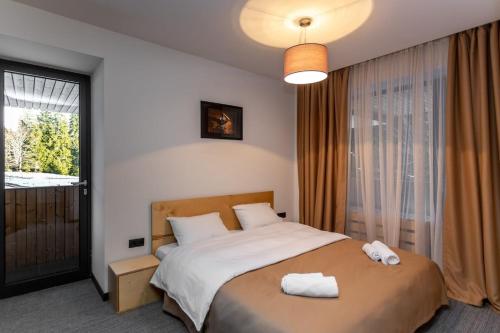 a bedroom with a bed with two towels on it at 1BR Apart In Kokhta Mitarbi in Bakuriani