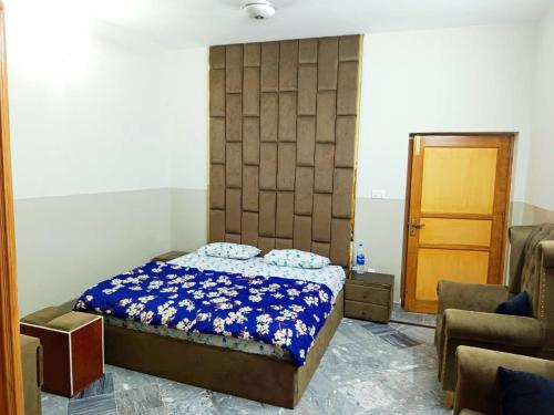 a bedroom with a bed and a chair and a door at Skyline Serenity Guest House in Rawalpindi