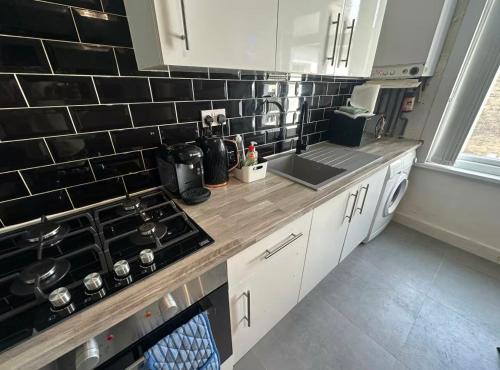 une cuisine avec un évier et un plan de travail dans l'établissement HP Wizards Corner Spacious 4 bed near Watford Junction, à Watford