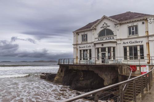 a building on a pier next to the ocean at The Wee Snug Portrush in Portrush