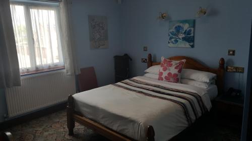 a bedroom with a bed with a pink pillow at Balkan Lodge Oxford in Oxford