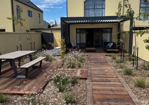 a backyard with a wooden deck and a picnic table at The Kings Domain, DUCHESS - Luxurious townhouse in the CBD! in Blenheim