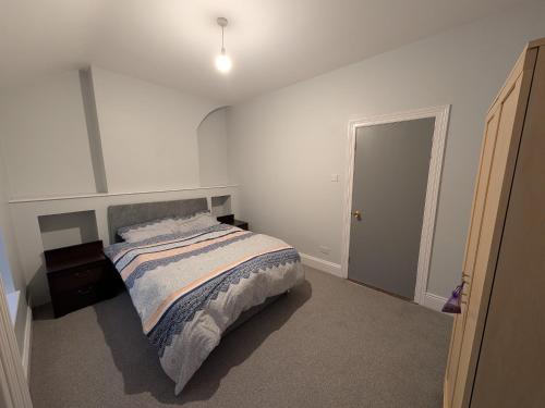a white bedroom with a bed and a door at Quiet Private Room in Prime Location in Derry Londonderry