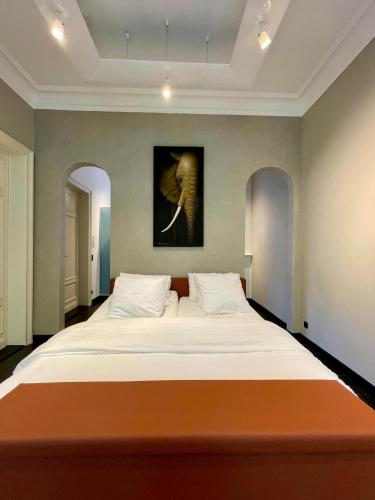 a large bed in a bedroom with a painting on the wall at La Ruche Oostende in Ostend