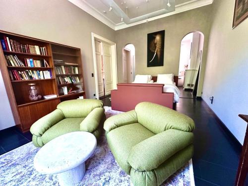a living room with two green chairs and a bed at La Ruche Oostende in Mellet