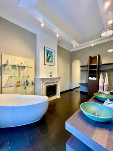 a large bathroom with a large tub and a fireplace at La Ruche Oostende in Ostend