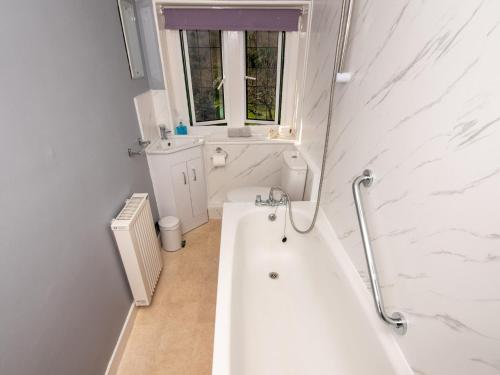 a white bathroom with a tub and a sink at 2 Bed in Studland DC069 in Studland