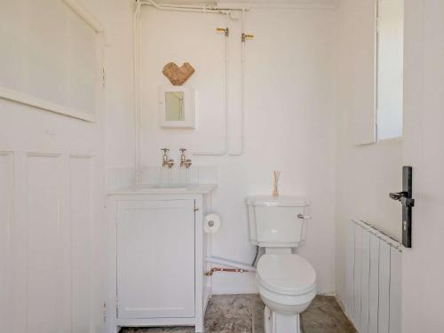 Worth Matraversにある4 Bed in Isle of Purbeck IC036のトイレと洗面台を備えた白いバスルーム