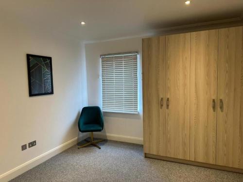 a room with a chair next to a door at The Cassius Apartment Huntingdon in Huntingdon