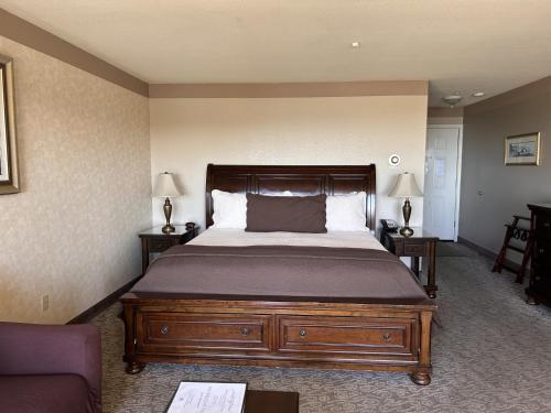 a bedroom with a bed and two tables and a couch at North Cliff Hotel in Fort Bragg