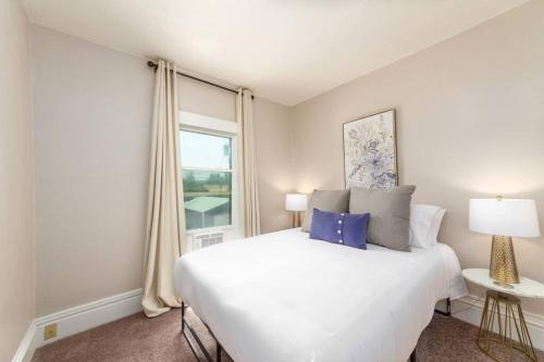 スポケーンにあるHistoric 3 Bed 1 bath Near Downtown Spokaneの白いベッドと窓のある寝室