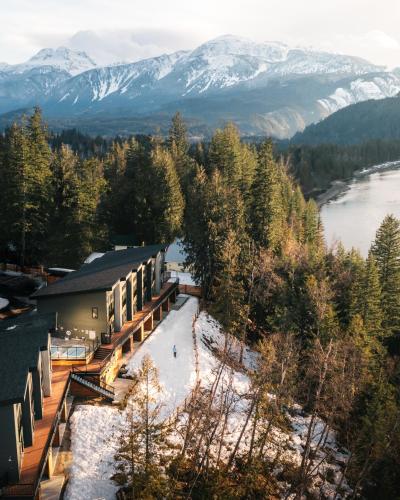 an aerial view of a ski lodge with a river and mountains at Basecamp Resorts Revelstoke in Revelstoke