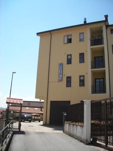 a large yellow building with a gate and a parking lot at Hotel Caimo Bed-Breakfast in Lagonegro