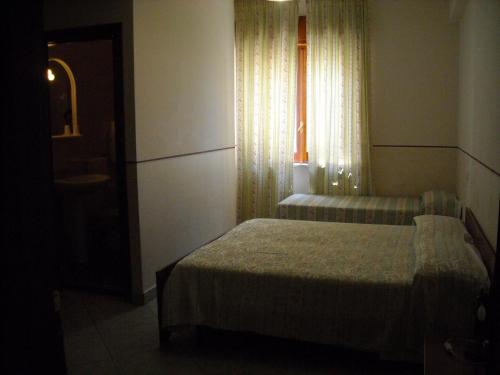 ラゴネグロにあるHotel Caimo Bed-Breakfastの小さなベッドルーム(ベッド2台、窓付)