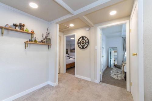 a hallway with a clock on the wall and a bedroom at Adorable 2 BD 1 BTH Home Minutes Away from Gonzaga in Spokane